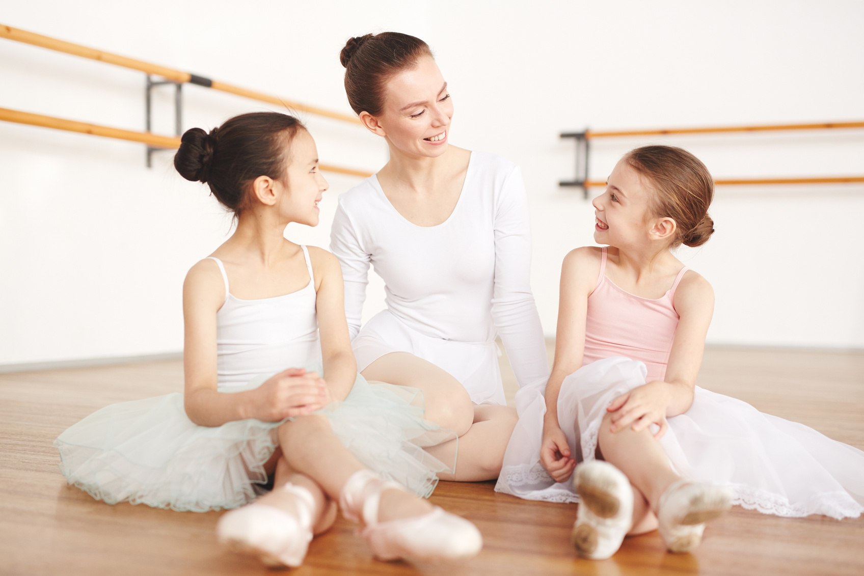 Ballet teacher and little students on floor